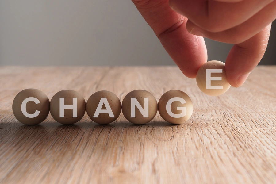 zmiana – metody lean management (Dłoń kładąca na blacie kulki z literami, układające się w napis "change")