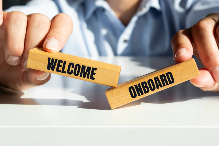 Onboarding w firmie (dwa drewniane prostokąty: jeden z napisem: welcome, drugi: onboard)