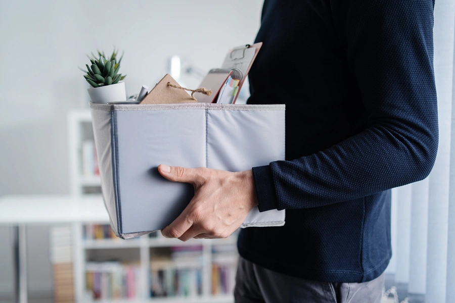 How to conduct offboarding (male hands hold a box of office stuff)