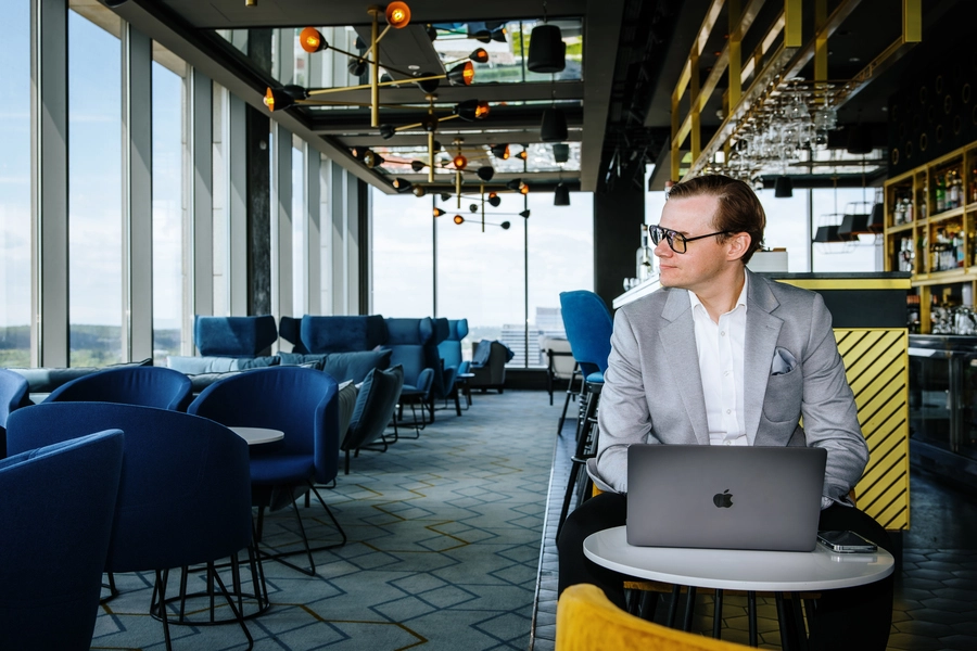 Adrian Stelmach siedzi w restauracji z laptopem