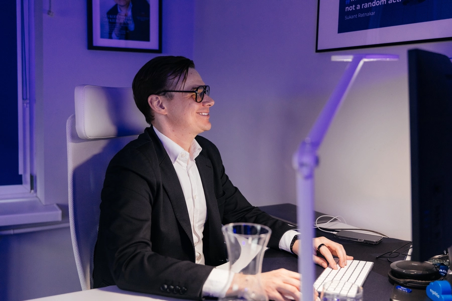 wdrożenie agentów AI (Adrian Stelmach przy biurku z komputerem)