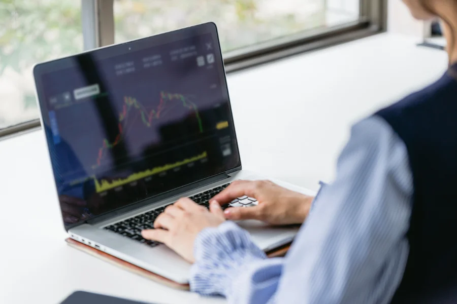 stopa zwrotu z inwestycji w AI - jak policzyć? (osoba sprawdzająca wykres na laptopie)