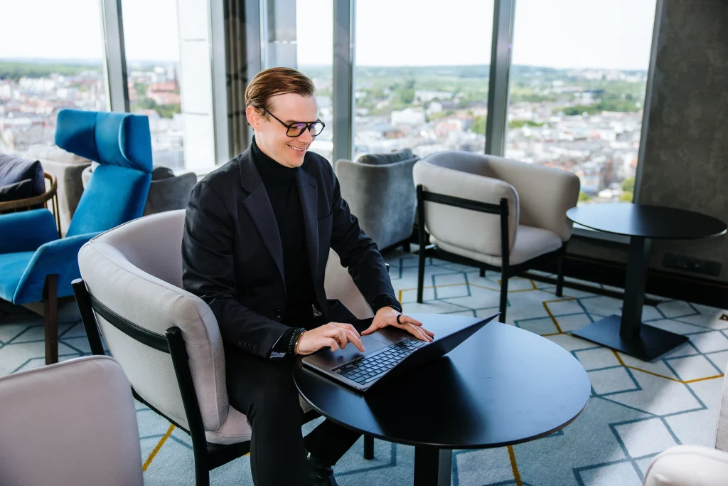 Etapy cyfryzacji - diagnoza musi poprzedzać kolejny krok (Adrian Stelmach przy stole z laptopem)